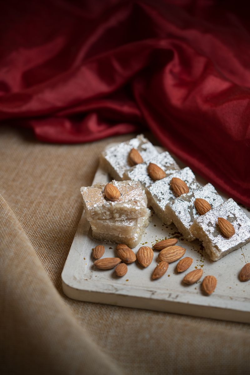 Diamond-cut kaju katli barfi with almonds, fresh off the tray.